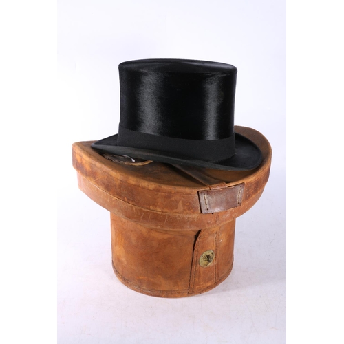 125 - London Manufacture top hat with fitted leather box, gloves and tie.