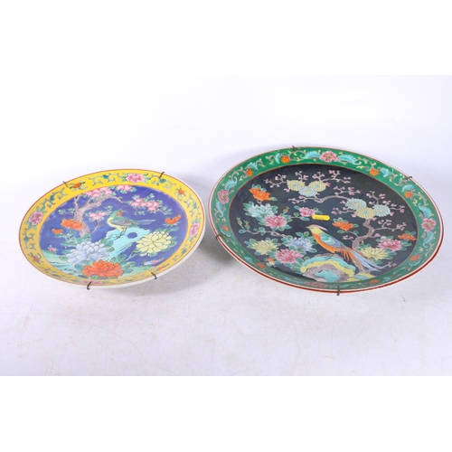 143 - Two Chinese wall plates decorated with birds amongst flowers, largest measures 31cm.