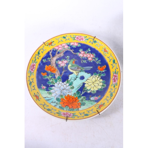 143 - Two Chinese wall plates decorated with birds amongst flowers, largest measures 31cm.