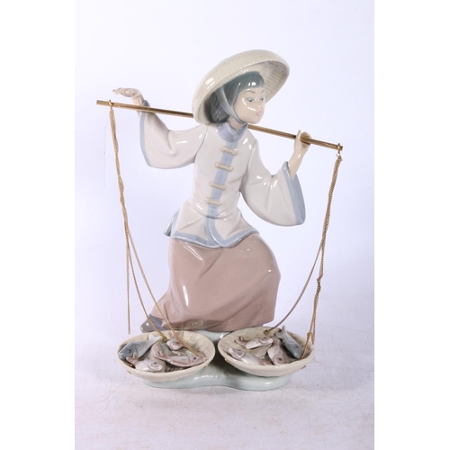 18 - Lladro figure of a fisherwoman, and two Nao figures.