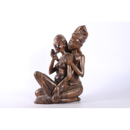 22 - Carved Eastern figure of a couple, and another humorous carved wood figure of a gentleman.