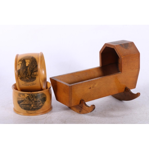 29 - Mauchline Ware crib, two similar napkin rings, a cigarette box in the form of a Swiss chalet, and a ... 