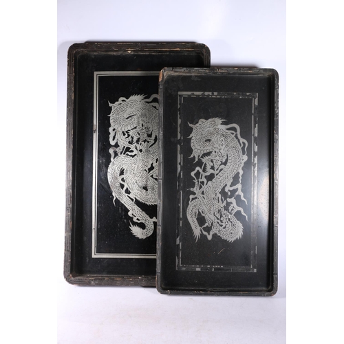 73 - Two Chinese lacquered trays decorated with dragons, largest measures 61cm x 36cm.