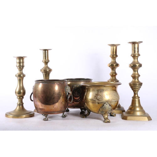 83 - Four brass candlesticks, and three small brass pots.