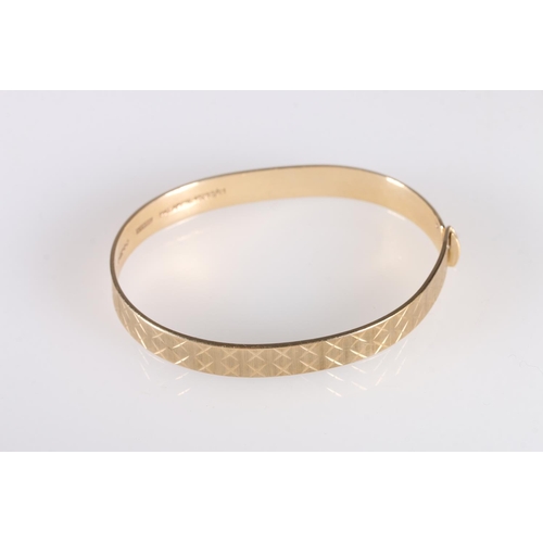 103 - Contemporary 9ct gold bangle with cross design, makers Maylin Products Ltd of London, further stampe... 