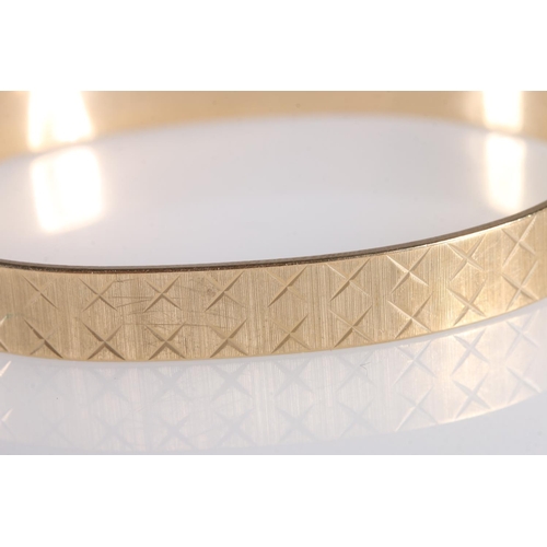 103 - Contemporary 9ct gold bangle with cross design, makers Maylin Products Ltd of London, further stampe... 