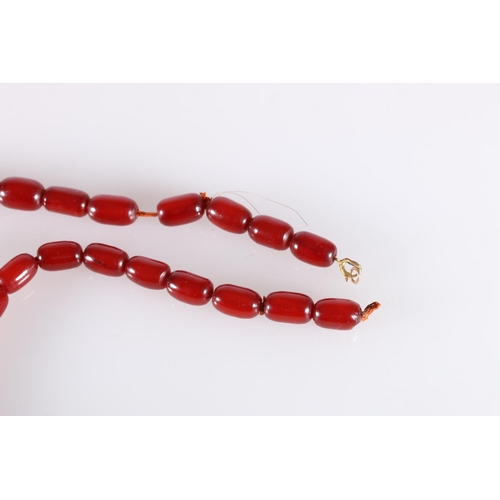 118 - Large single strand necklace of graduated cherry red amber beads, the largest bead over 2.5cm long, ... 