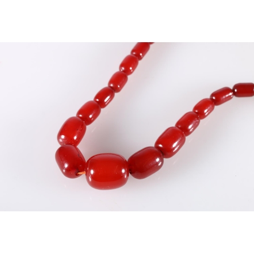 118 - Large single strand necklace of graduated cherry red amber beads, the largest bead over 2.5cm long, ... 