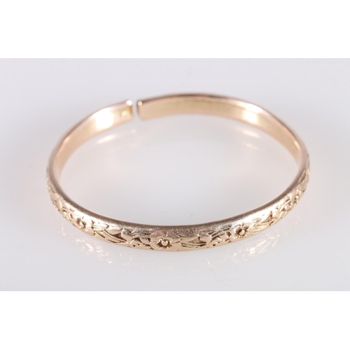 126 - Rose gold coloured yellow metal West Indian bayras bangle with floral pattern, unhallmaked, 37.4g gr... 