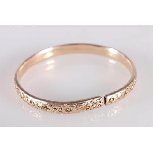 126 - Rose gold coloured yellow metal West Indian bayras bangle with floral pattern, unhallmaked, 37.4g gr... 