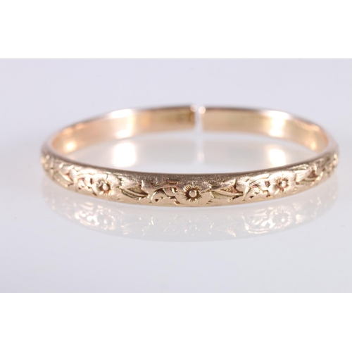 126 - Rose gold coloured yellow metal West Indian bayras bangle with floral pattern, unhallmaked, 37.4g gr... 