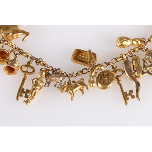 144 - Gold charm bracelet with 23 charms including seahorse, scorpion, heart, key, telephone, elephant, wi... 