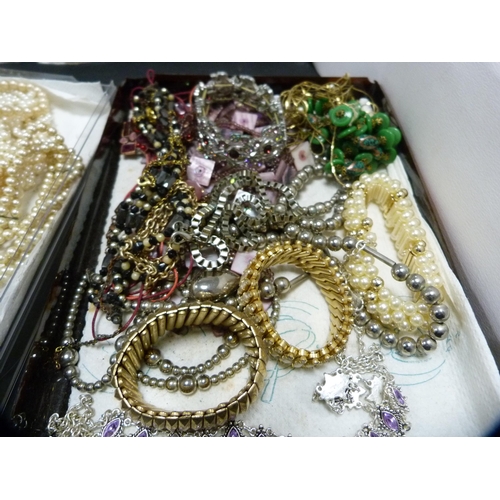 241 - Two shallow boxes containing costume jewellery to include synthetic pearls, beads etc.