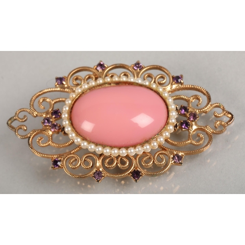 108 - Pink enamel cabochon, seed pearl, and amethyst set yellow metal brooch