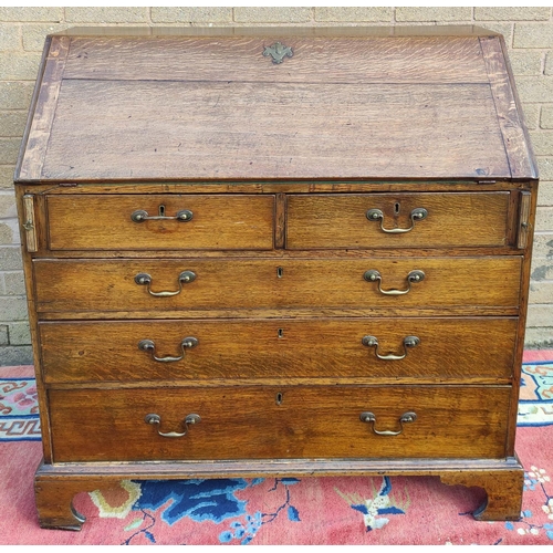 411 - Georgian oak writing bureau with fall front, enclosing fitted drawers and pigeon holes, above two sm... 