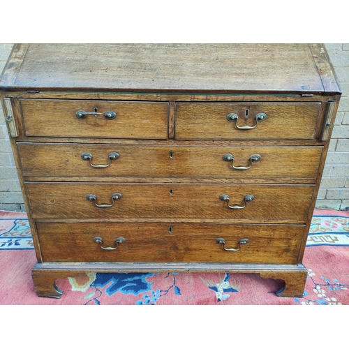 411 - Georgian oak writing bureau with fall front, enclosing fitted drawers and pigeon holes, above two sm... 