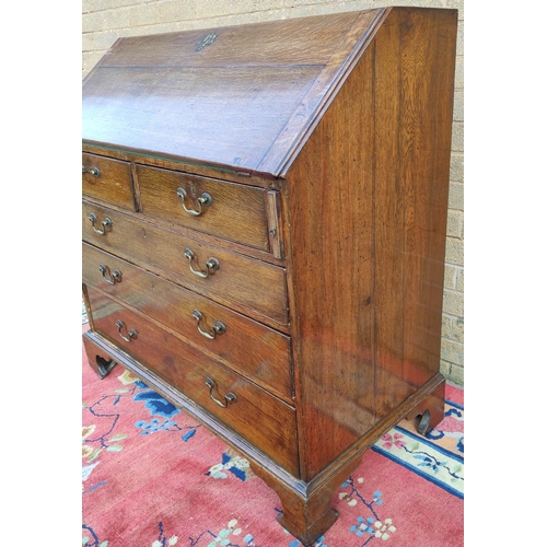 411 - Georgian oak writing bureau with fall front, enclosing fitted drawers and pigeon holes, above two sm... 