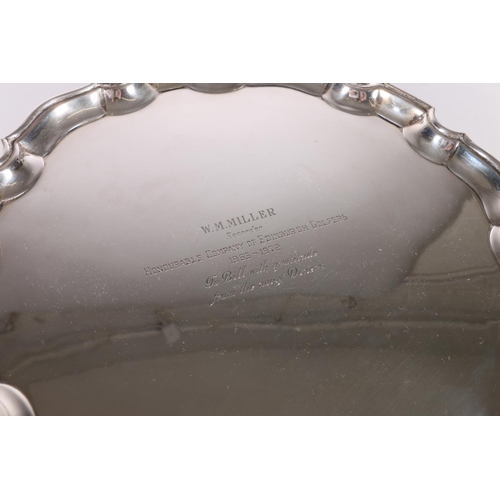 25 - Elizabeth II silver salver with piecrust edge, raised on three scroll supports, presentation inscrip... 