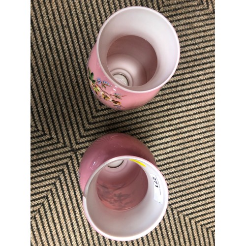 271 - Pair of semi-opaque pink overpainted glass vases, decorated with flowers, 27cm high.