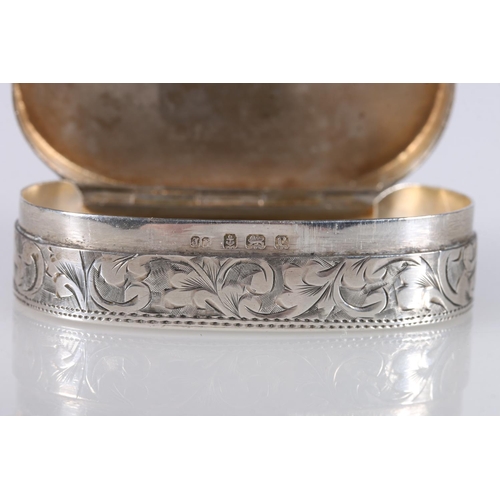 60 - Edward VII antique silver snuff box of oval shape, the body decorated with engraved floral design wi... 