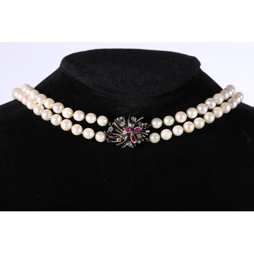 207 - Double strand pearl necklace of uniform size pearls, the 18ct gold white metal clasp set with ruby a... 