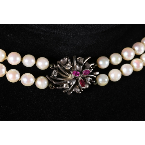 207 - Double strand pearl necklace of uniform size pearls, the 18ct gold white metal clasp set with ruby a... 