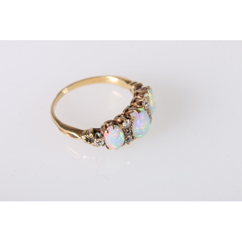 214 - Unhallmarked yellow metal gem set ring, the three oval opals surrounded by eight diamond, ring size ... 