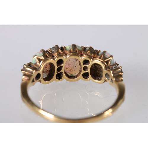 214 - Unhallmarked yellow metal gem set ring, the three oval opals surrounded by eight diamond, ring size ... 