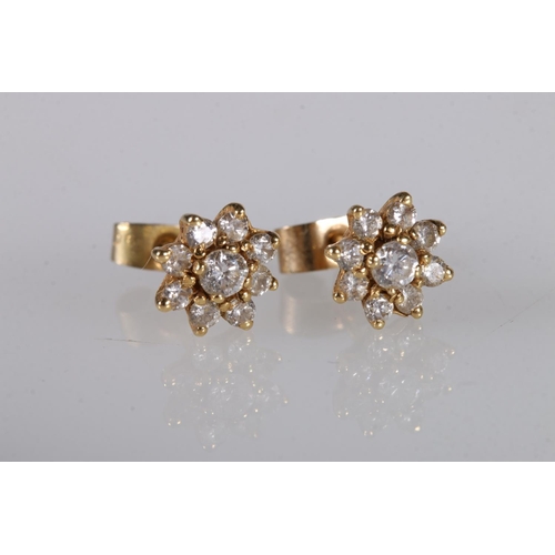 216 - Pair of yellow gold ear studs set with diamond in a flower head form, marks rubbed, 2g gross. 