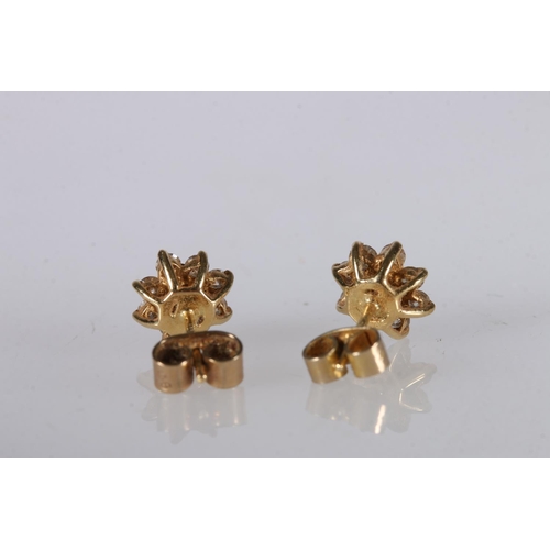 216 - Pair of yellow gold ear studs set with diamond in a flower head form, marks rubbed, 2g gross. 