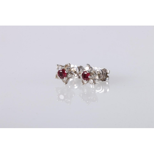 218 - 18ct white gold ruby and diamond ear studs set in flowerhead form, 1.7g gross. 