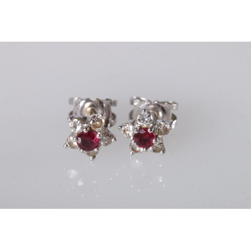 218 - 18ct white gold ruby and diamond ear studs set in flowerhead form, 1.7g gross. 