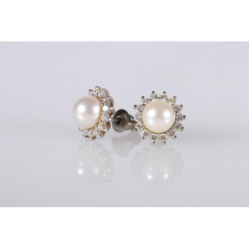 219 - Pair of 18ct white gold ear studs, the central pearl encircled by diamonds in a flowerhead form, 4.2... 