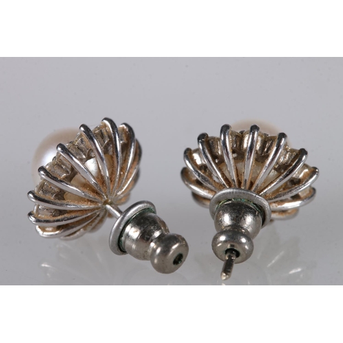 219 - Pair of 18ct white gold ear studs, the central pearl encircled by diamonds in a flowerhead form, 4.2... 