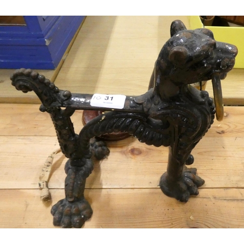 31 - Large cast iron fire dog, a bell also a tape measure.