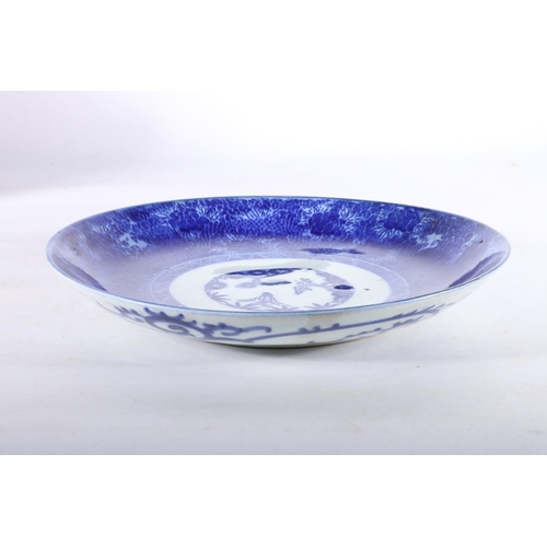 486 - Oriental blue and white porcelain charger dish, the interior with three blossoming trees, the floral... 