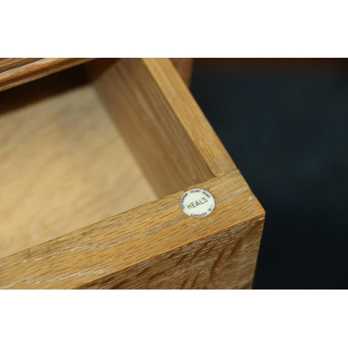 516 - Heals of London, a limed oak ledge back bedside cabinet, Heals button to the inside of the drawer, 7... 