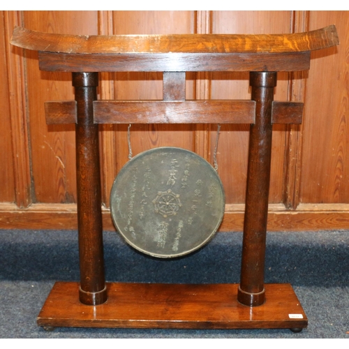 526 - Chinese gong, the oak frame of temple form supporting a circular bronze gong with character mark and... 