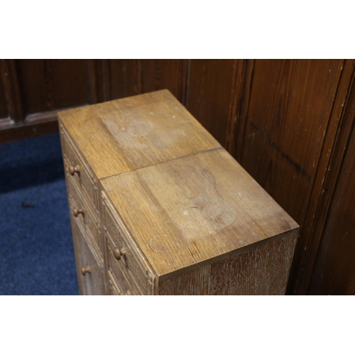 517 - Heals of London, a limed oak cabinet (made up) having four short drawers above two cupboard doors, r... 