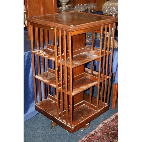 501 - Antique oak revolving bookcase of square section with three tiers of shelves, 115cm tall.