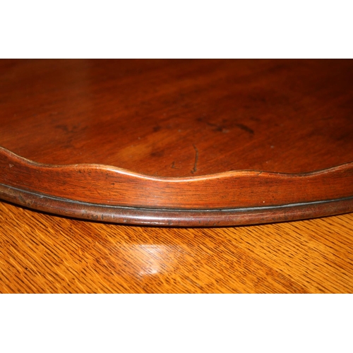 514 - Antique mahogany oval tray with serpentine gallery and twin metal handles, 78cm wide.