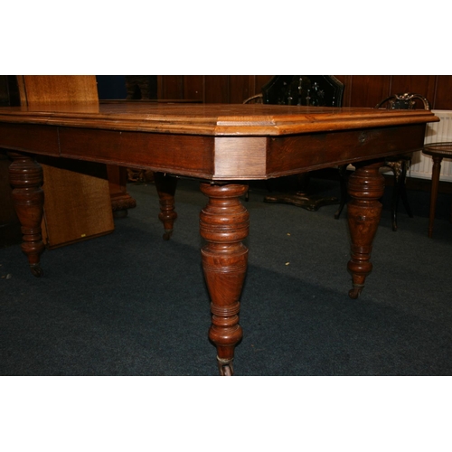 533 - Victorian oak telescopic dining table, the rectangular top with canted corners, raised on turned sup... 