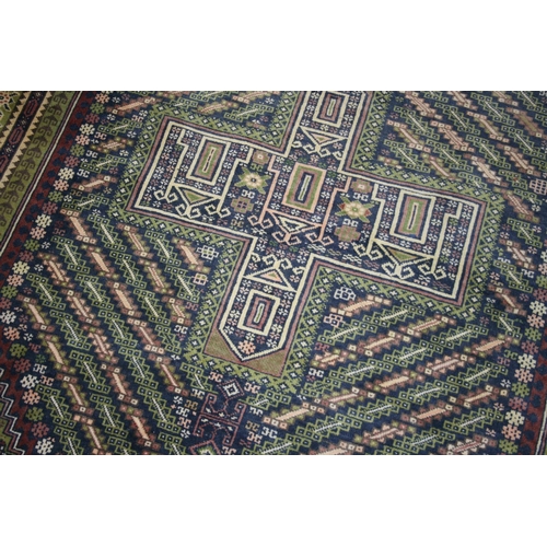 537 - Persian style green ground rug, the midnight blue field with large central lozenge having cross to t... 