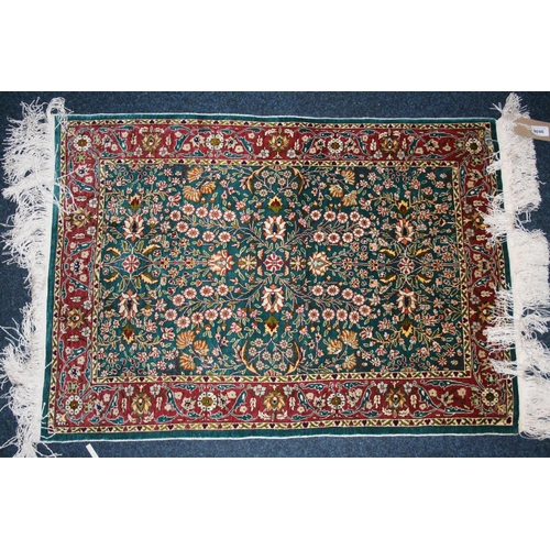 540 - Indian silk rug, the green field decorated with millefiori design, red borders, fringed ends, 93cm x... 