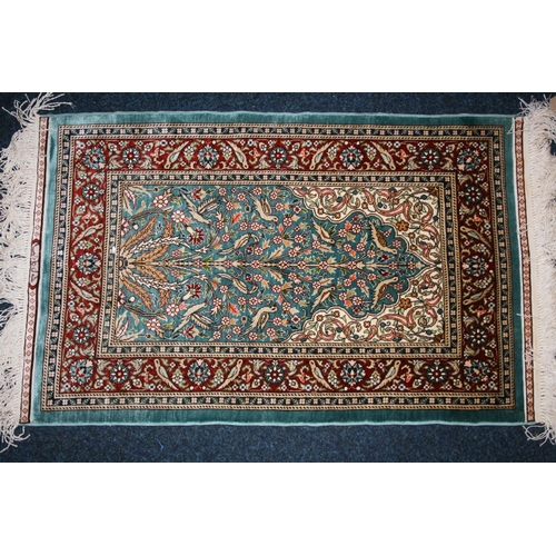 542 - Indian or Turkish silk rug, the green field decorated with flowering branch design, multiple guard b... 