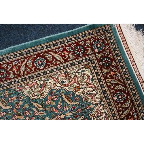 542 - Indian or Turkish silk rug, the green field decorated with flowering branch design, multiple guard b... 