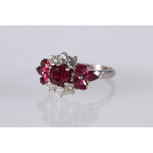 260 - 18ct white gold ruby and diamond ring, the large, faceted ruby surrounded by six diamonds and six ru... 