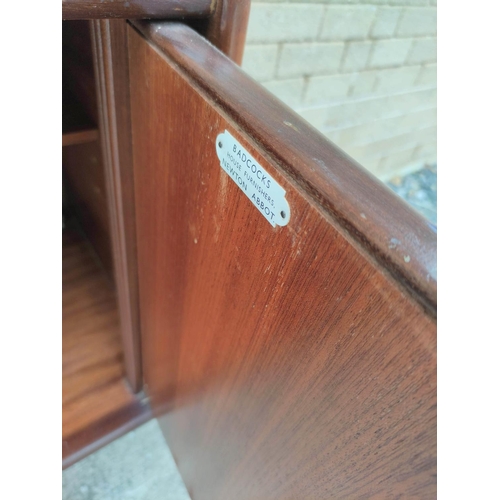 395 - Mid Century teak sideboard by Badcocks House Furnishers Newton Abbot, with four central drawers flan... 