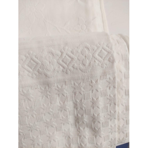 217 - Woven white cotton bedspread, approx. 215cm x 220cm; a set of twelve embroidered cutwork white linen... 