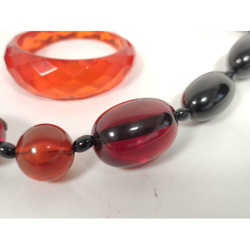 133 - Amber bead necklace of graduated oval beads and a faceted bangle.